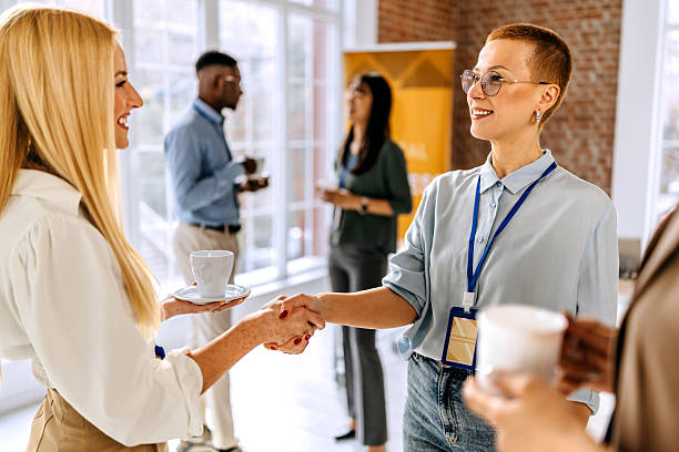 istock Two female colleagues shaking hands during a coffee break at a conference 2207927852
