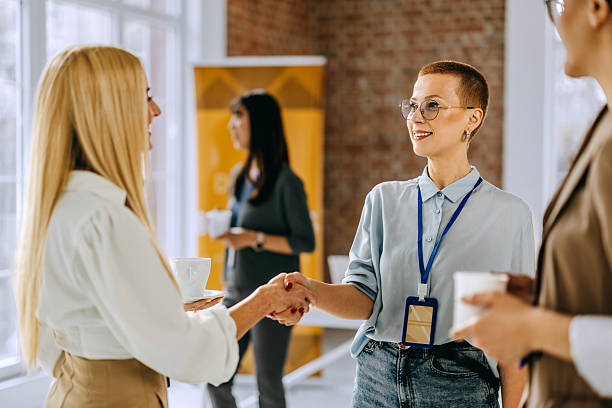 istock Two female colleagues shaking hands during a coffee break at a conference 2207927908