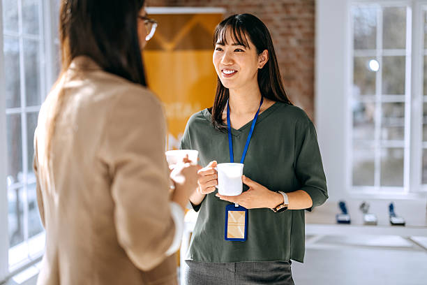 Two female colleagues enjoying a coffee break during a conference
