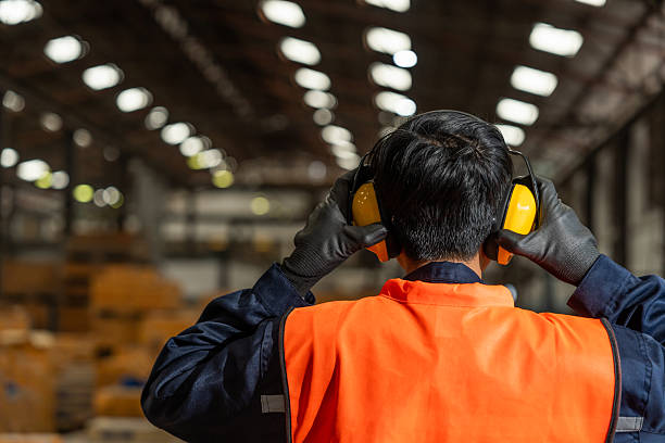 Close up technician engineer wearing and adjust protective safety ear plug Safety equipment for industry factory. Safety at work concept.