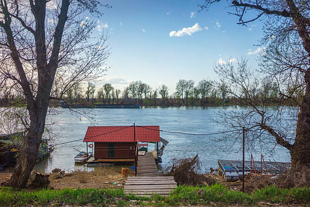 Small wooden houses by the river Sava in Serbia. Early spring, cloudy but nice weather.