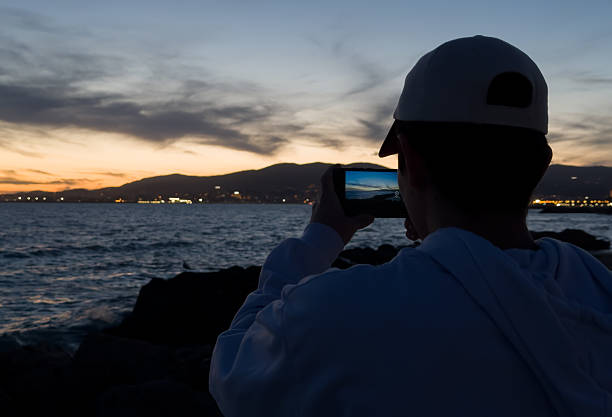 istock Man photographing a sunset with his smartphone 2207930315