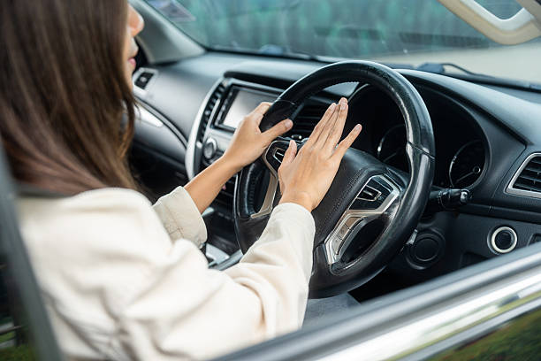 istock Hand woman pushing car horn while driving car. 2207930472