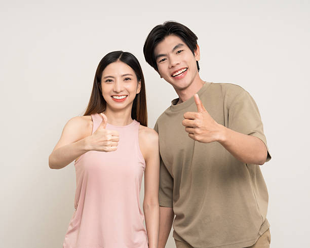 istock Happy asian couple attractive in various action gesture standing on isolated white background. Cheerful Smiling young man and woman showing thumbs 2207932034