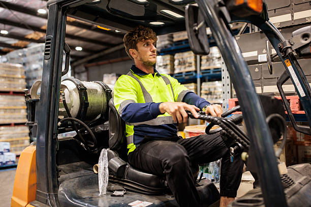 istock Warehouse Worker in Reflective Clothing Operating Forklift 2207932887