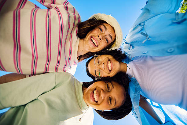 istock Three Gen Z girls embracing and smiling at the sky 2207935556