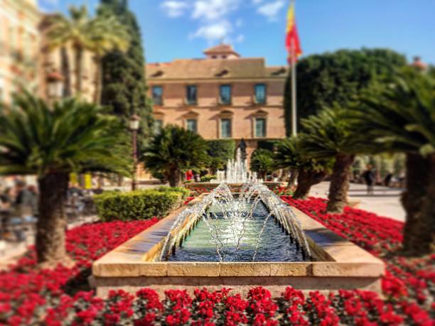 istock Water feature view with red flowers and town hall buildings 2207938063