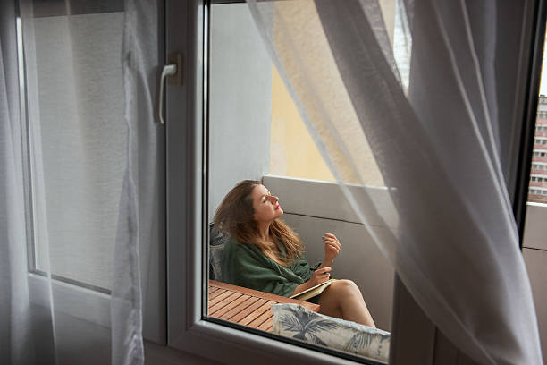 istock Woman Relaxing on Balcony with Book and Soft Light 2207938539