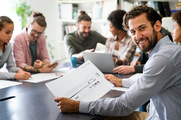 istock Diverse group of happy employees analyzing reports with digital device, working together in office 2207941278