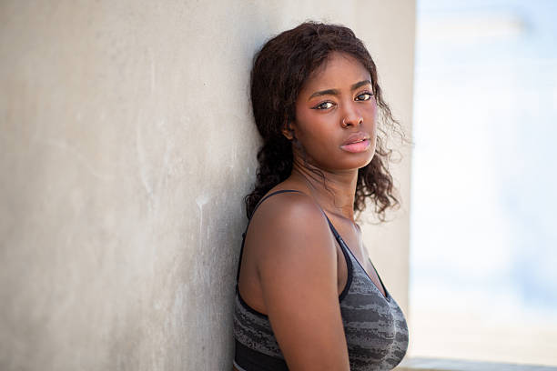 istock contemplative woman leans against wall 2207942512