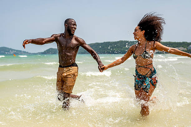 istock Joyful Couple Running Through Ocean Waves on Beach 2207944192