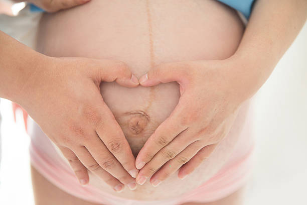 Portrait of young parents and their little girl looking at the camera. Woman is expecting a baby.