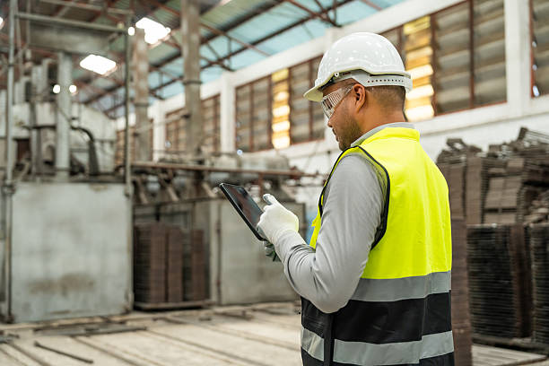 istock Confident engineer man with safety helmet standing analyzing with tablet in factory warehouse. Asian technician factory inspection and control machinery in industry factory. 2207947371
