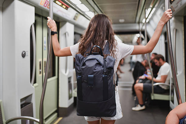 istock Female Backpacker Holding On to Handles for Balance While Riding in Subway 2207947815