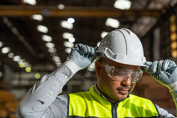 istock Close up technician engineer wearing and adjust protective safety helmet or hard hat. Safety equipment for industry factory. Safety at work concept. 2207949091