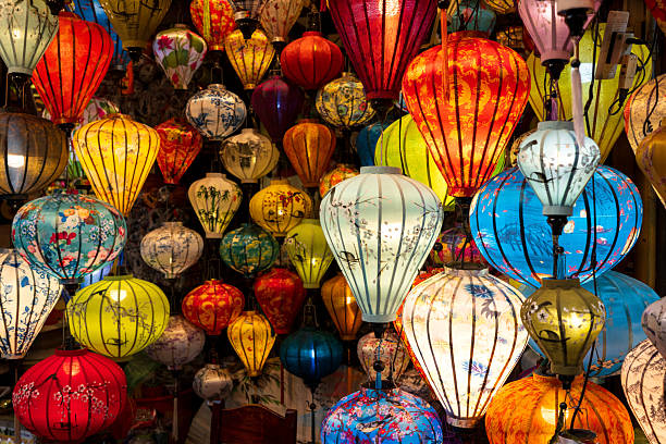 istock Vibrant, intricately patterned lanterns in assorted shapes and colors hang gracefully along a timeworn Vietnam market, showcasing exquisite traditional artistry. 2207950041
