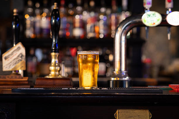 ein erfrischendes pint lagerbier auf der theke - bar stock-fotos und bilder