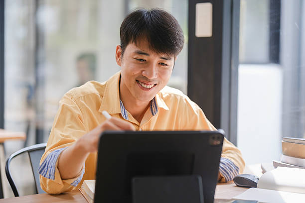 istock Student studying online and preparing for exams with digital devices and books 2207951801