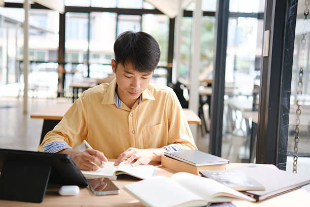 istock Student studying online and preparing for exams with digital devices and books 2207951818