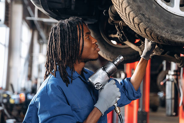 istock Automatic screwdriver in hand. Male mechanic is with car in garage 2207952463