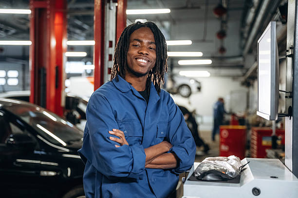 istock Stationary computer with display. Male mechanic is with car in garage 2207954764