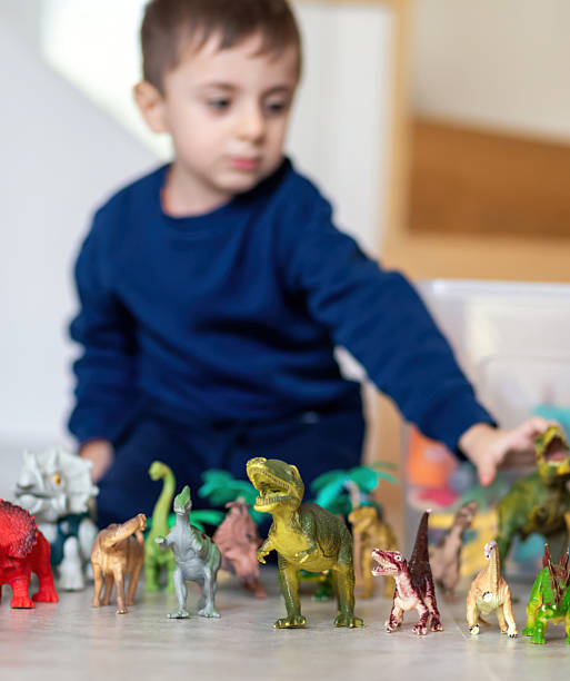 istock Child playing with dinosaur toys on the floor 2207961082