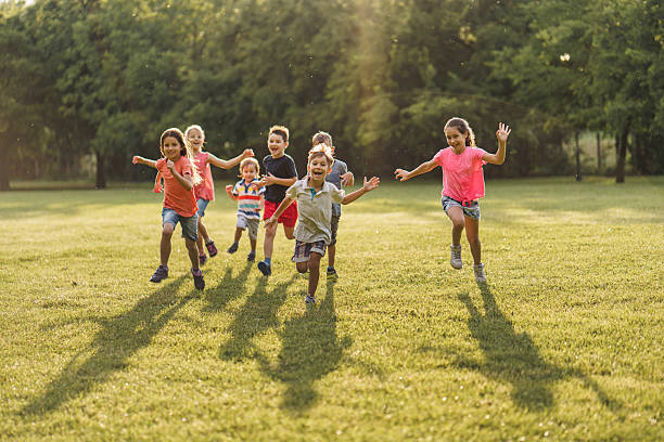 istock Joyful children having fun running in public park 2207964455