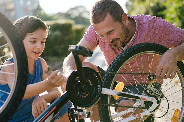 istock Father teaching son how to fix a bicycle 2207964569