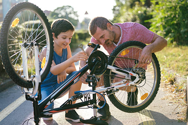 istock Father and son working on bike in sunlight 2207964574