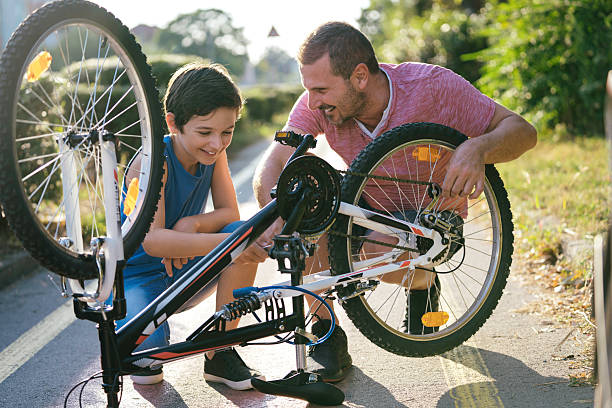 istock Happy child learning bicycle maintenance with dad 2207964576