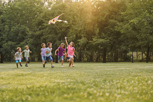 istock Happy children playing whit kite toy in park 2207964728
