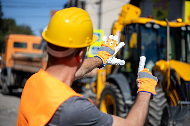 istock Construction worker directs heavy machinery on a busy site in broad daylight 2207965842