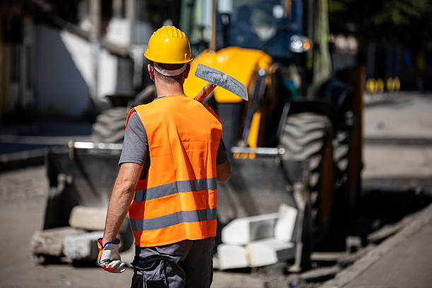 istock Construction worker prepares for roadwork during the day with heavy machinery in the background 2207966107