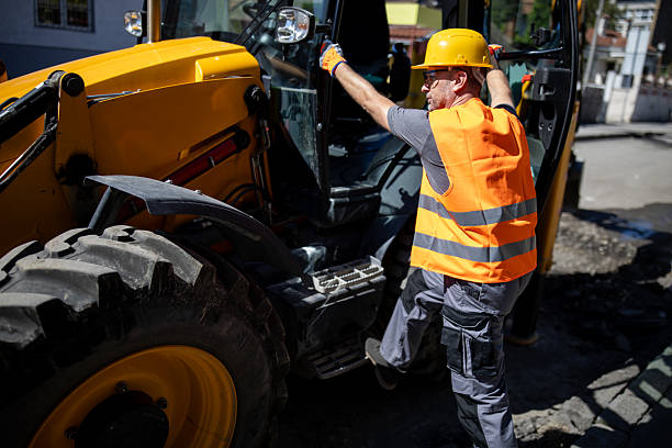 istock Worker operating construction machinery on urban site during daytime 2207966294