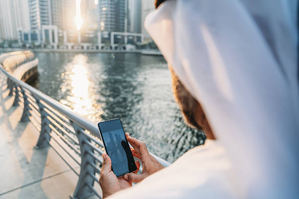 istock Emirati businessman using smartphone in Dubai Marina at sunset 2207968780