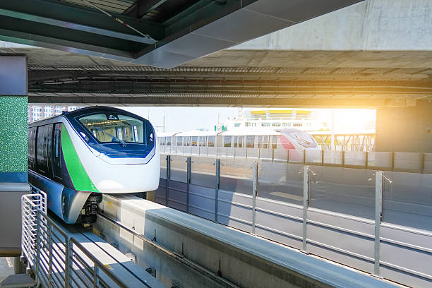 istock Two monorail train with bright headlights passes race station on the stage through a tunnel at a road junction 2207969321