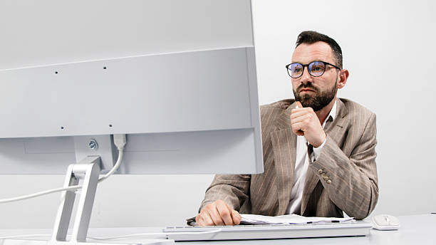 istock Business man working in a light modern office at the computer. 2207969587