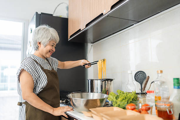 istock senior woman boiling spaghetti in home kitchen 2207972881