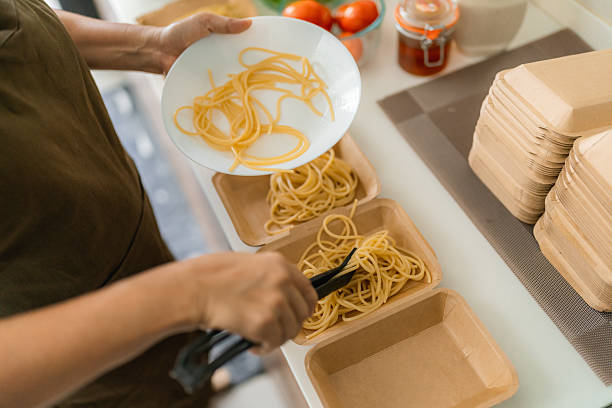 senior woman boiling spaghetti in home kitchen, cooking healthy and nutritious food with care for her small business customers
