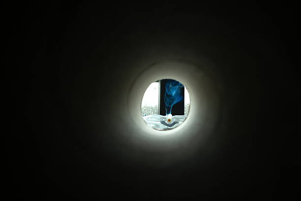 istock View of a cigarette in an ashtray from a dark hole 2207976653