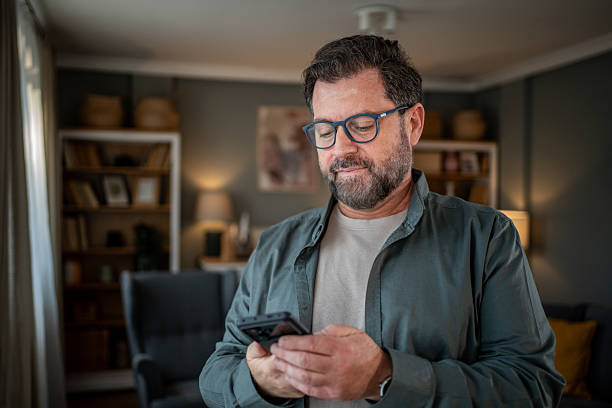 istock Mature man using smartphone at home: browsing internet and social media 2207978263