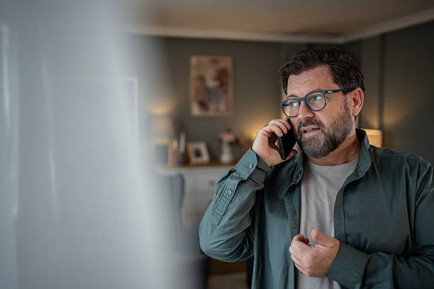 istock Worried mature man talking on smartphone at home 2207978295