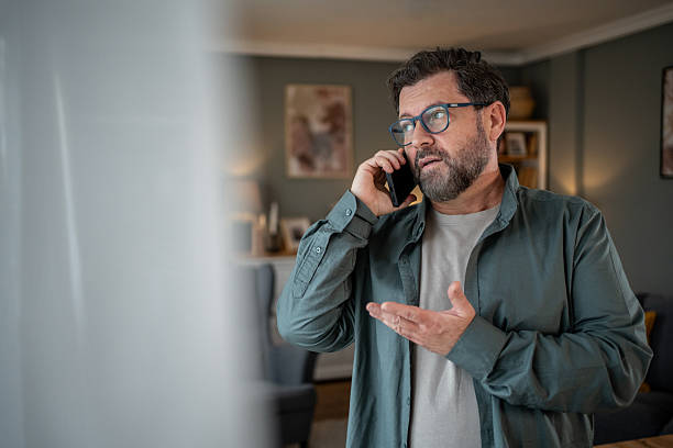 istock Worried mature man talking on smartphone at home 2207978298