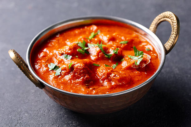 istock Chicken Tikka Masala in a copper bowl. Grey background. Close up. 2207982206