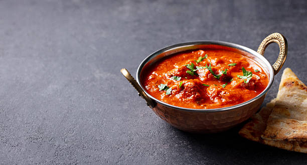 istock Chicken Tikka Masala in a copper bowl. Grey background. Close up. Copy space. 2207982412