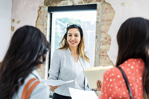 istock Businesswoman Meeting with Clients, Discussing Documents 2207984005