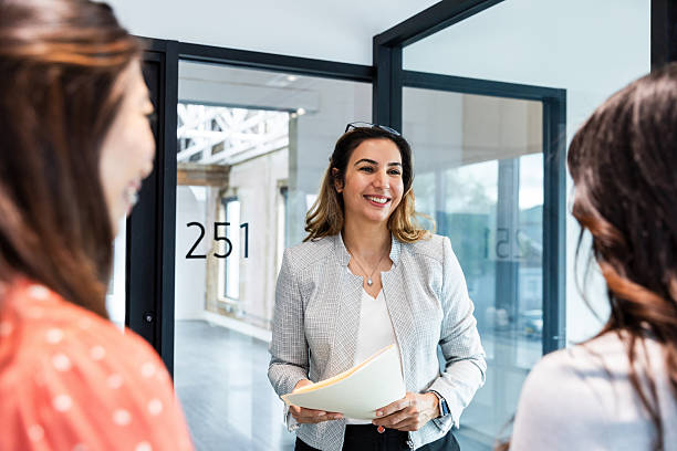 istock Confident businesswoman smiles, holding documents in modern office 2207984047