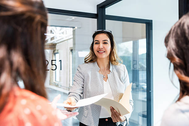 istock Businesswoman Sharing Documents with Colleagues in Office 2207984056