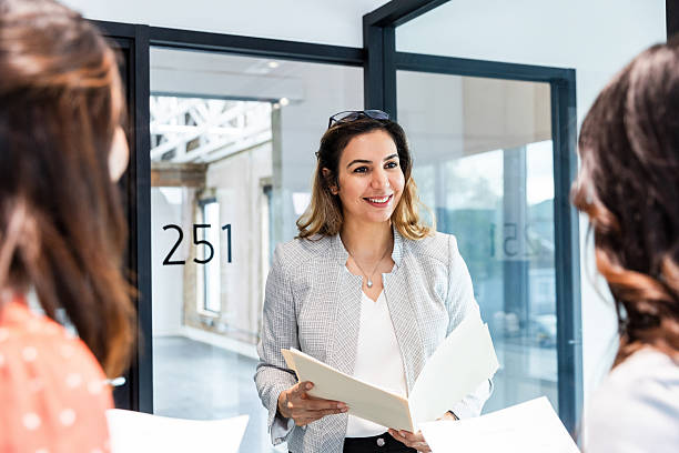 istock Businesswoman Discussing Documents with Colleagues in Modern Office 2207984059