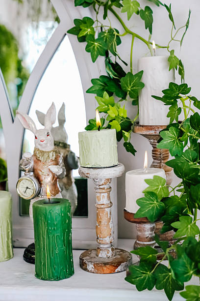 istock Decorative table arrangement with candles and a rabbit figurine surrounded by greenery 2207984238